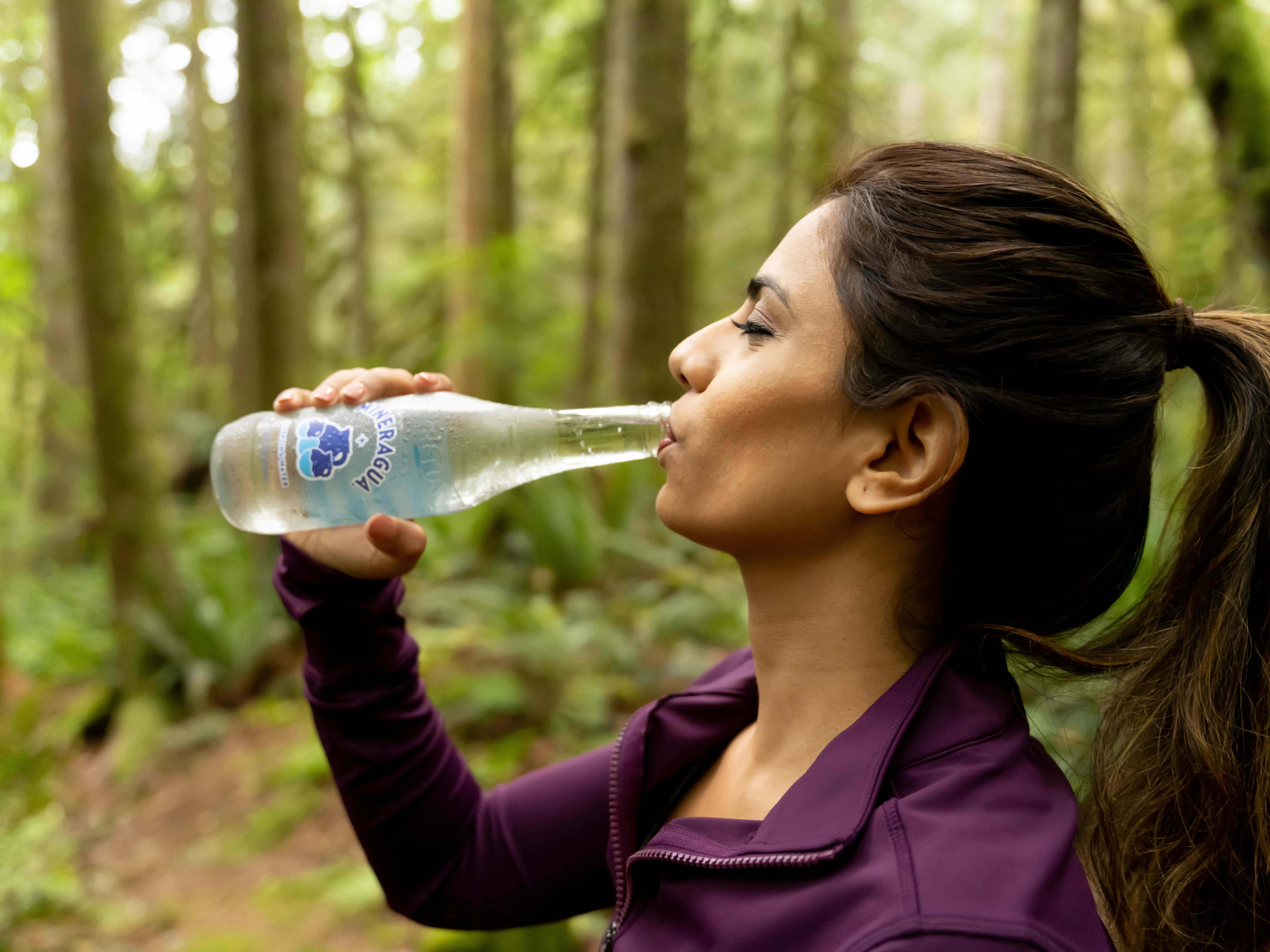 woman drinking carbonated water outside